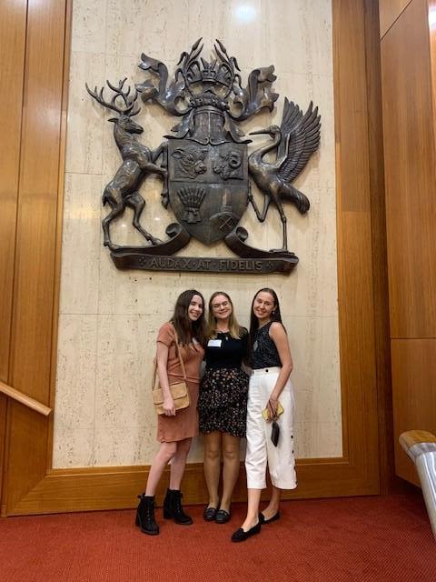 UQ students (L–R) Ailis Rogers, Sophie James and Nina Sarapa who volunteered on the EVAWQ project at Parliament House.