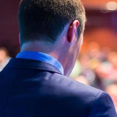 speaker from behind with audience in background