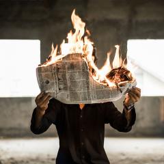 man reading newspaper on fire