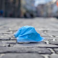 discarded surgical mask on a deserted cobblestone pedestrian street
