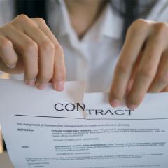 close up of hands tearing up a contract