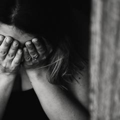 A woman crying into her hands. 