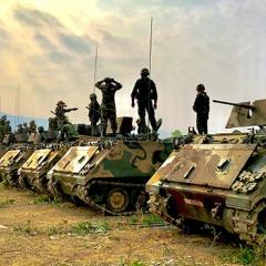 soldiers standing on top of tanks