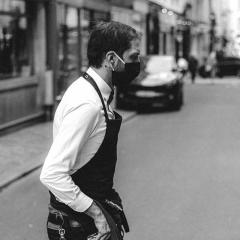 waiter in mask crossing the street