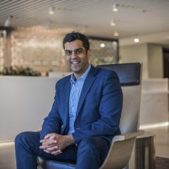 Milan Gandhi sitting down in his office lobby.