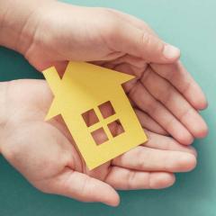 paper cut out of house in young hands
