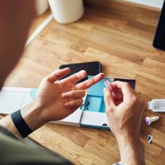 Man pricking his finger to draw blood for a home DNA test.