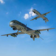 Two military drones flying in the sky