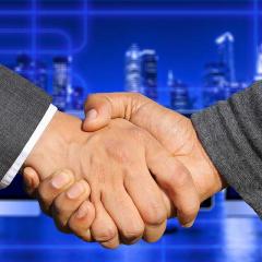 shaking hands in front of a city background