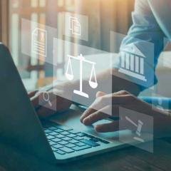 person at laptop with justice symbols overlaid