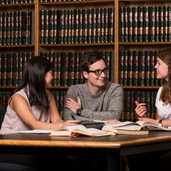 Three law students talking in Law library 