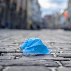 discarded surgical mask on a deserted cobblestone pedestrian street