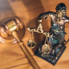small Lady justice statue and gavel on a desk. 
