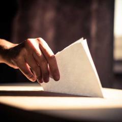hand putting ballot paper into box